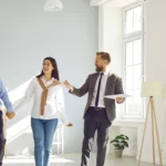 A professional realtor standing in front of a house, showcasing local expertise in buying, selling, and investing like a Realtor near me